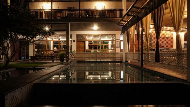 Exterior view of a luxury boutique estate villa surrounded by lush greenery in Wayanad, Kerala.